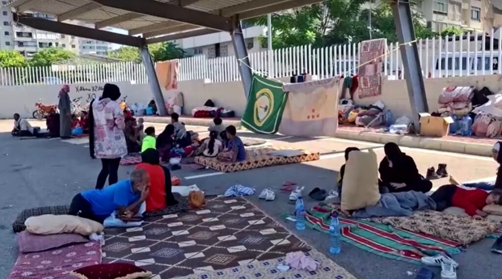 People fleeing southern Lebanon violence take shelter in parking lot in Sidon