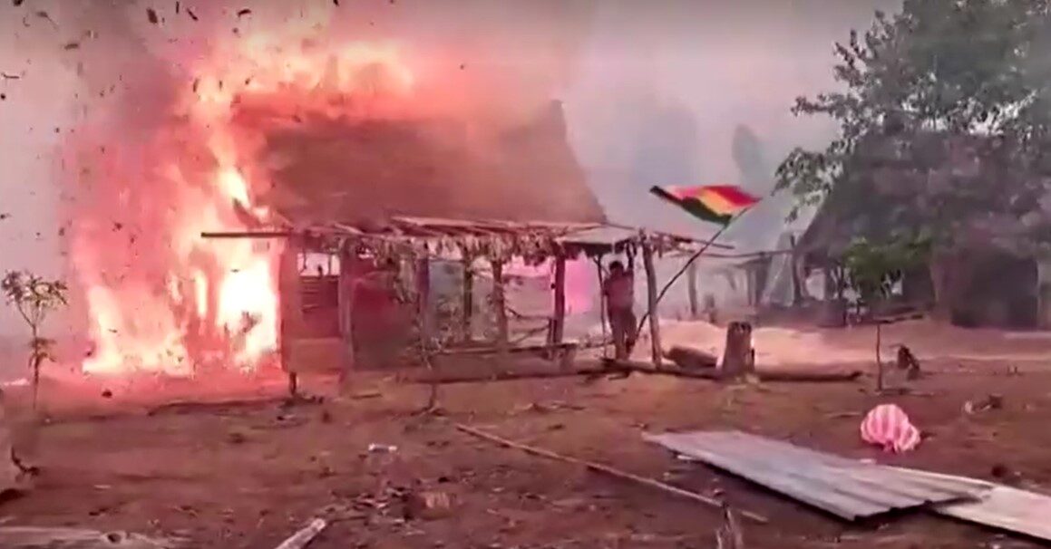 man salvaging belongings from burning home in Bolivia