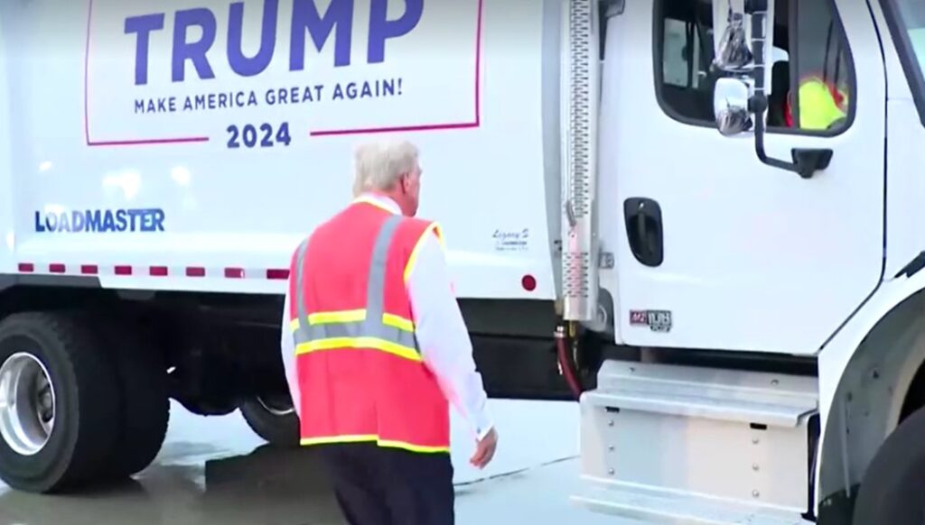 Trump walks to truck wearing a bright construction vest