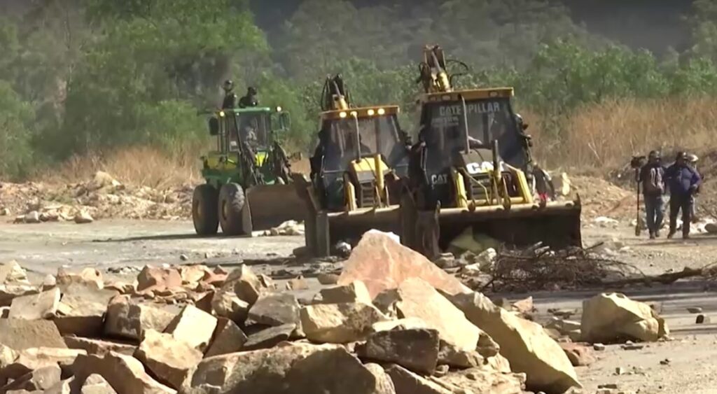 Heavy machinery removing rocks blocking road in Bolivia