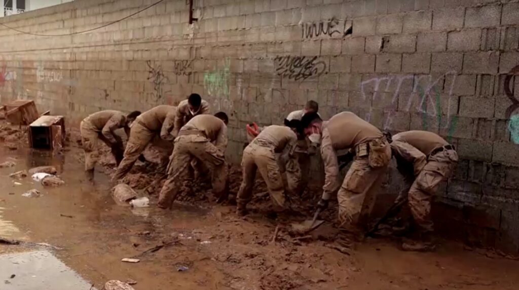 Spain soldiers clean street covered in mud