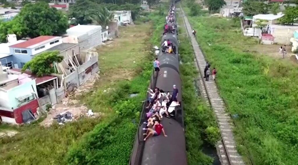 aerial view of migrant families risk life and limb to jump Mexico train