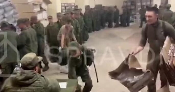 North Korean soldiers receiving gear from Russian soldiers