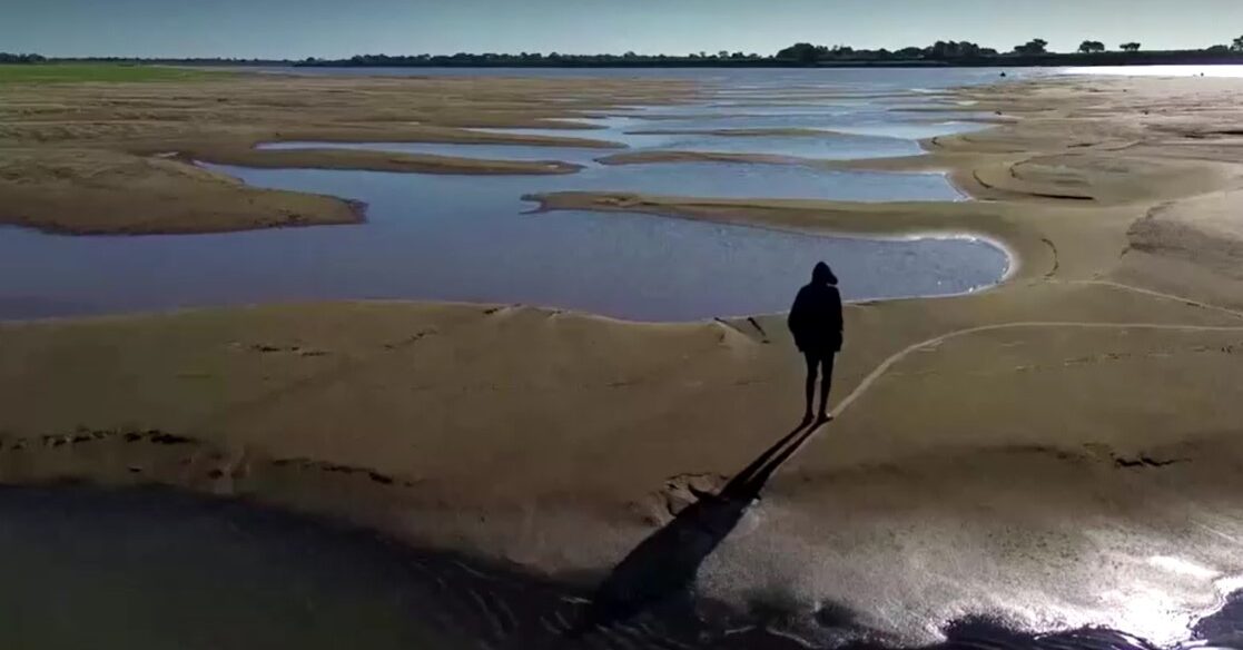 Man walking over the dry Solimoes riverbed