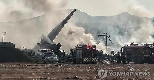 Smoke rises from the wreckage of the Jeju Air passenger plane that crashed at the Muan International Airport