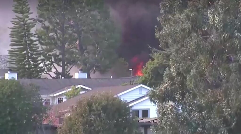 wildfire and huge plumes of smoke behind houses in LA