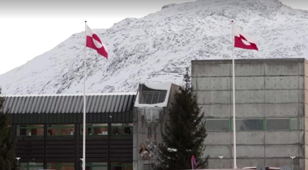 Greenland flags in front of snowy mountain