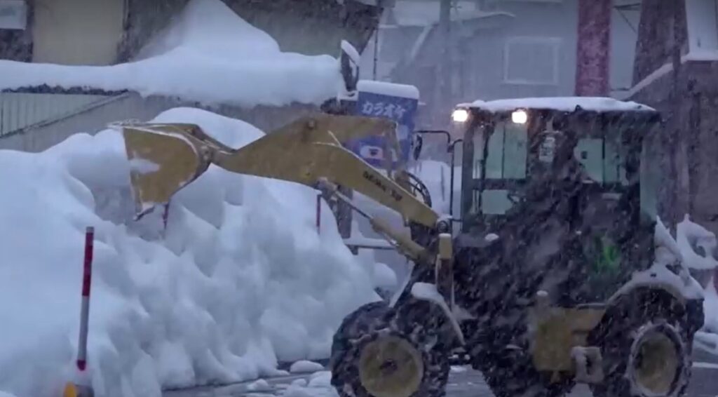 tractor clears snow from road in Japan