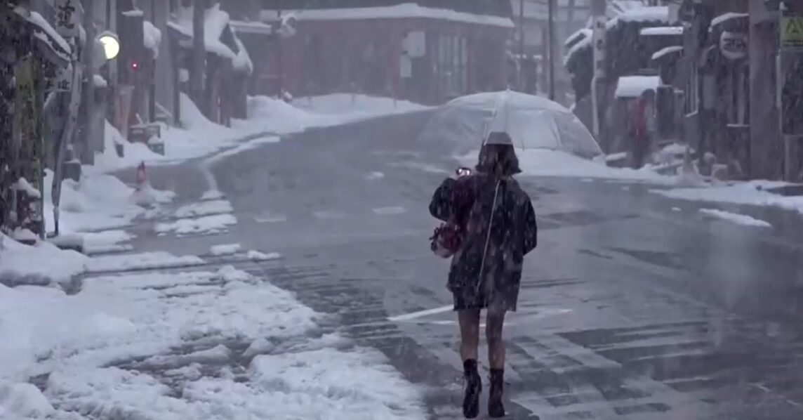 woman carries umbrella among heavy snow in Japan