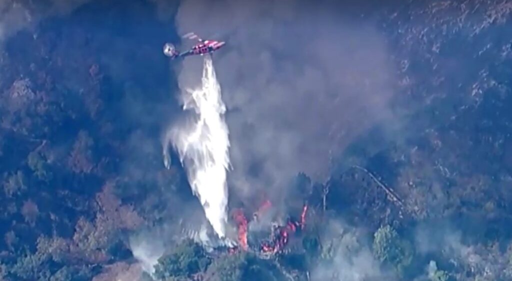 Helicopters dump water on burning Los Angeles home