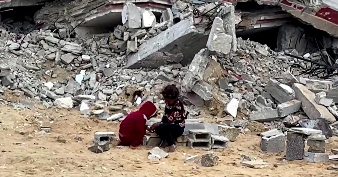 children play among debris in Gaza