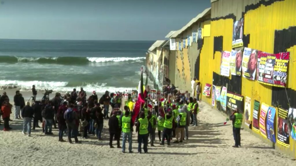 Activists rally against US anti-immigration policies at the U.S.-Mexico border fence located on the beaches