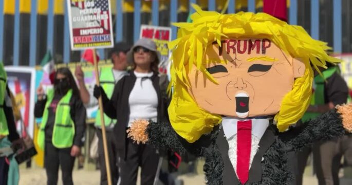 Activists rally against US anti-immigration policies, hit Trump piñata