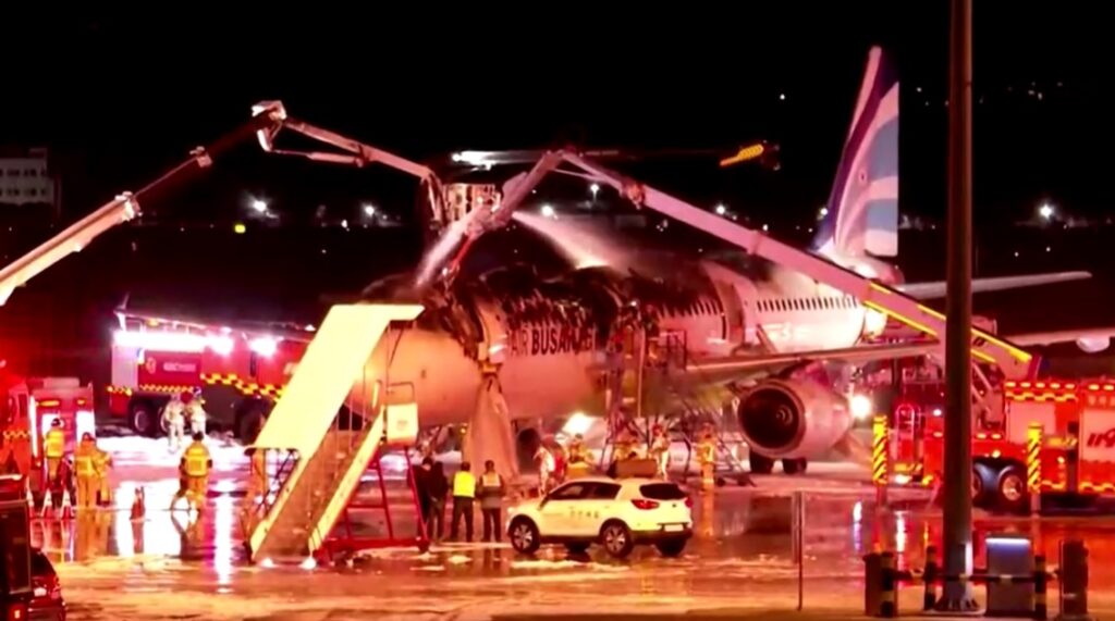 fire fighters try to extinguish fire on Air Busan