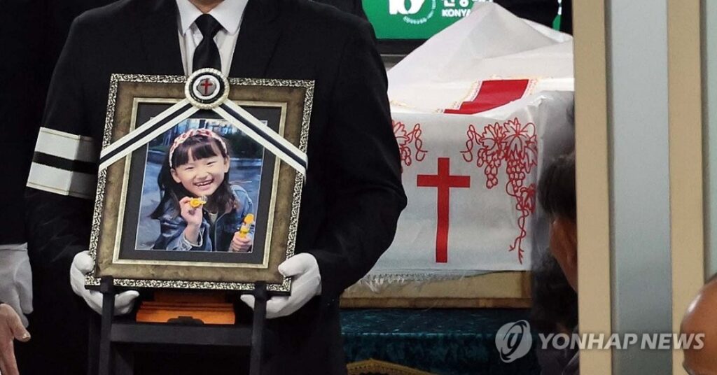 family member of Kim Ha-neul, an 8-year-old stabbing victim, carries her portrait 