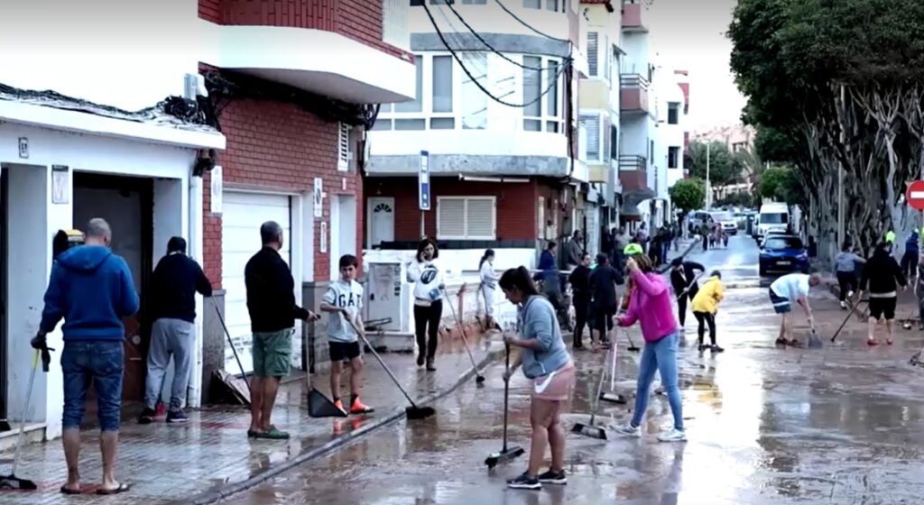 Residents in Gran Canaria clear the mud on street deposited by flood