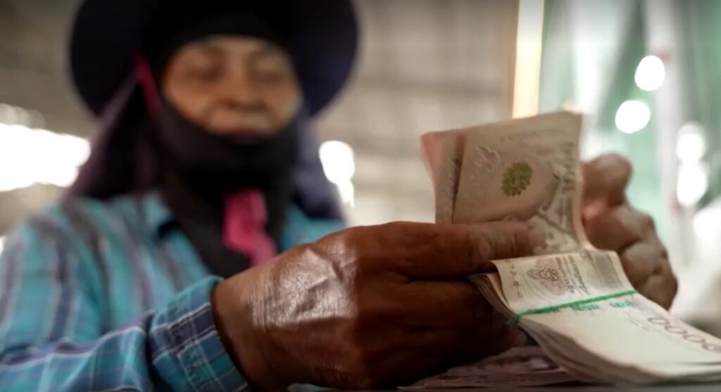 Thai farmer counts money from rice selling