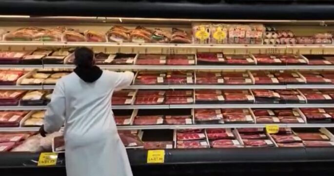 shopkeeper at meat shelve