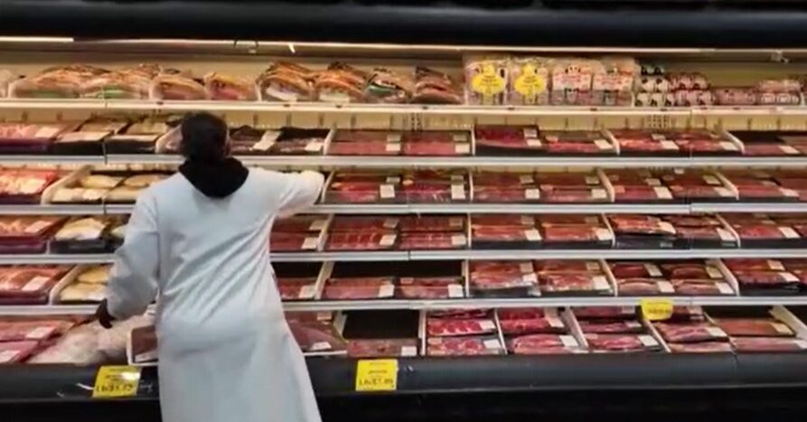 shopkeeper at meat shelve