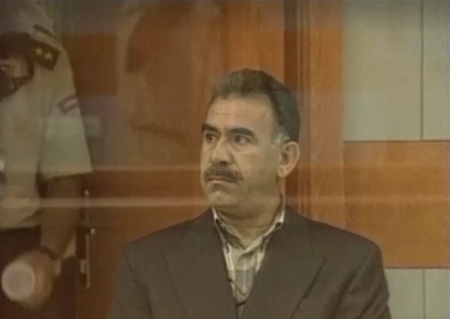 PKK leader Abdullah Ocalan sitting down in bullet-proof glass cage to hear verdict in Turkey in 1999