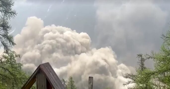 Glacier partially collapsed, creating a huge cloud towards Swiss village
