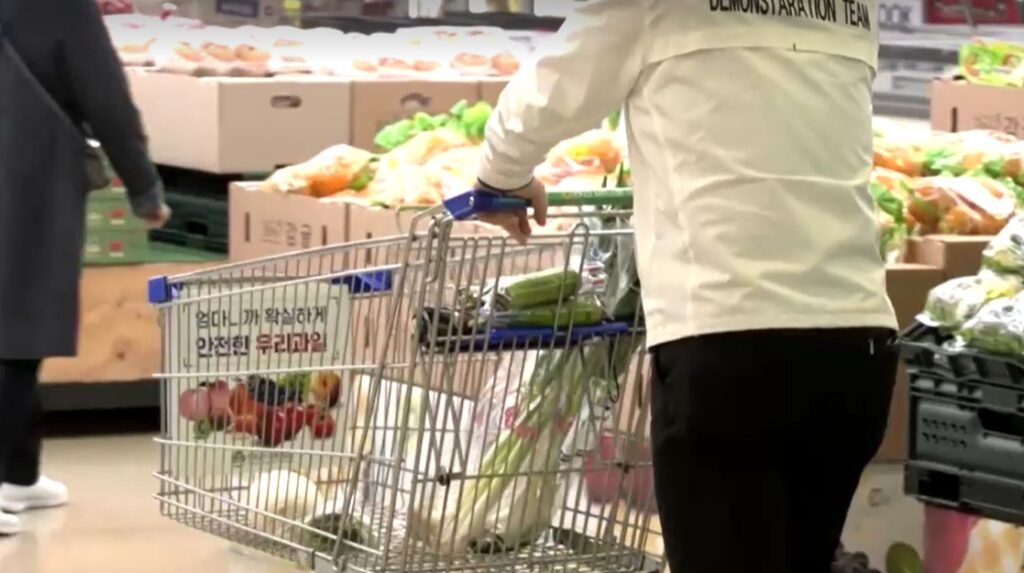 man pulls supermarket cart with little vegetables