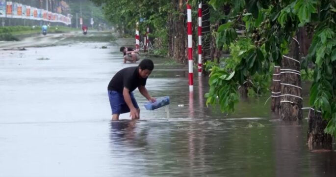 person on flooded road in Nghe An, Vietnam