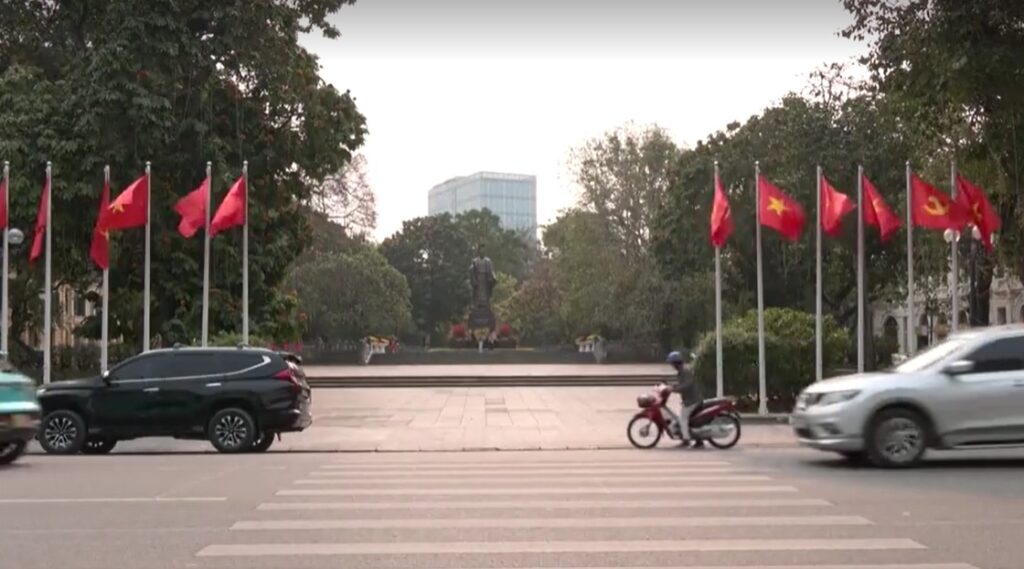 traffic in Hanoi, Vietnam with row of flags